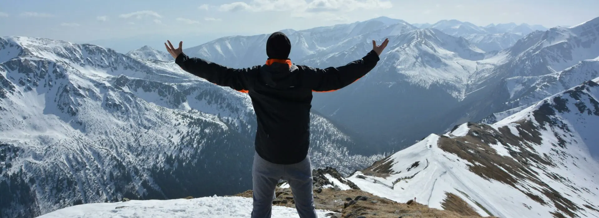 Hiker on top of a mountain celebrating with his arms outstretched