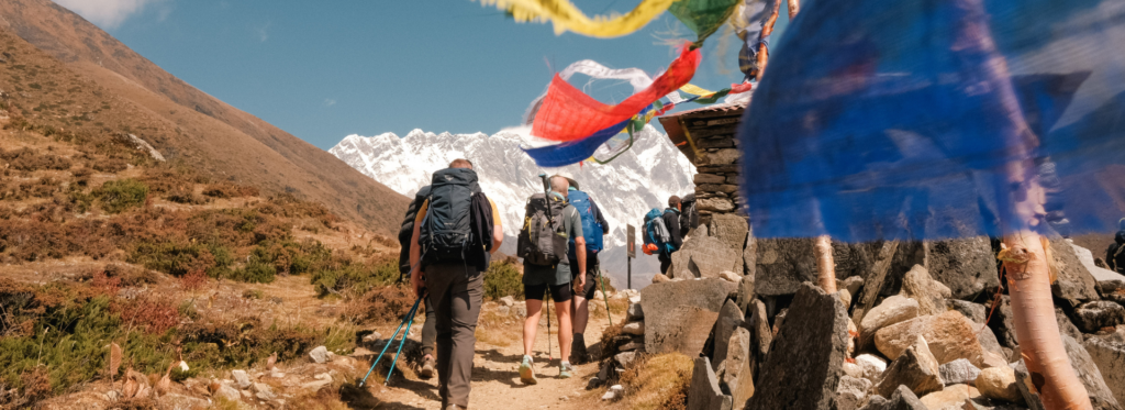 Earth’s Edge group trekking through the Himalayas with colourful prayer flags along the Everest Base Camp trail