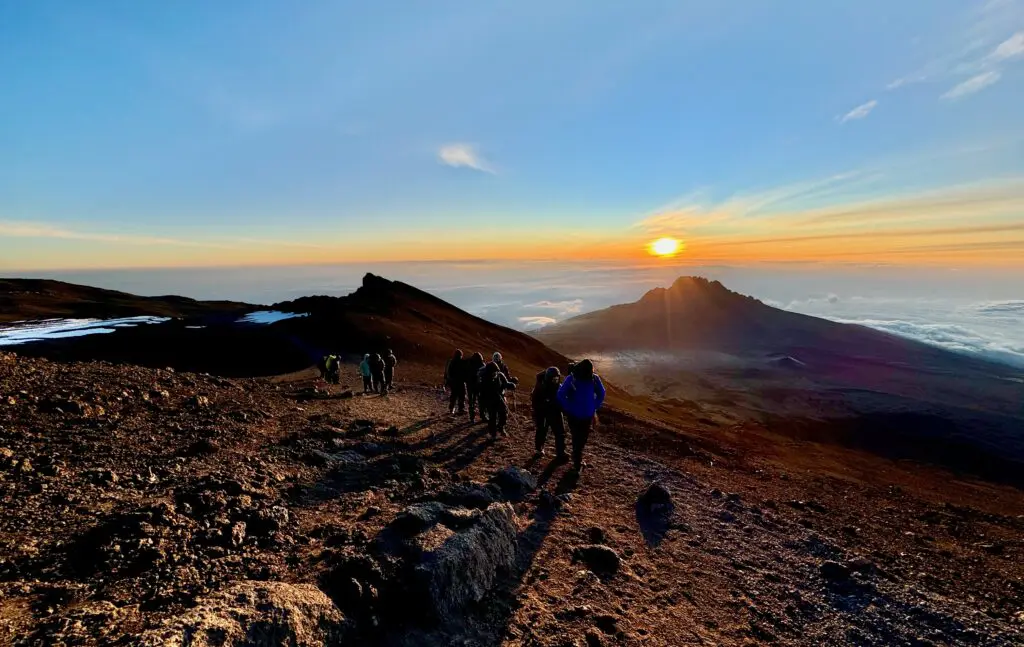 Beginner hikers summiting Kilimanjaro via the Machame Route at sunrise, Tanzania