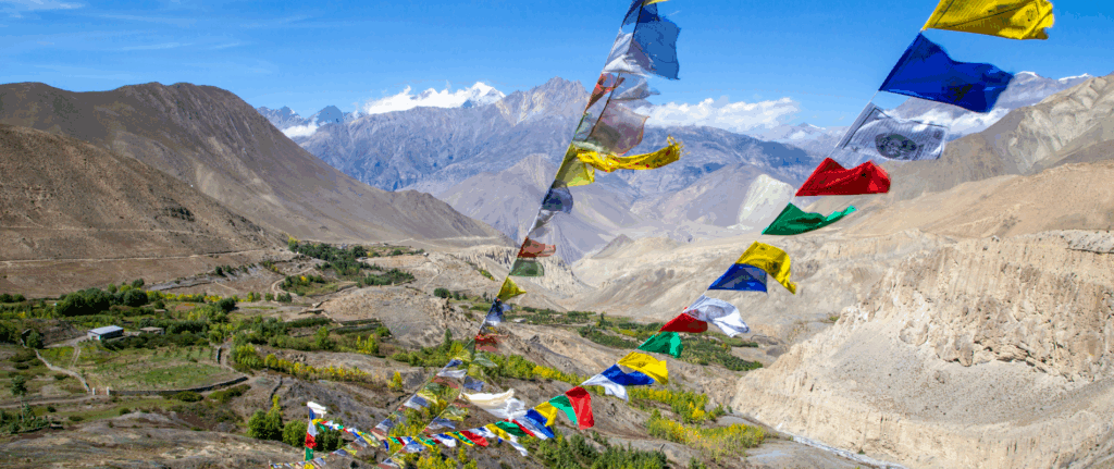 Overhead view of a section of the Annapurna Circuit, Nepal on a clear day, with prayer flags at the forefront