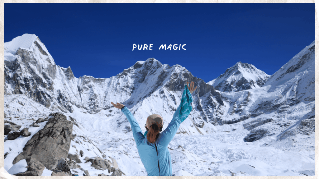 A trekker posing in front of snow-capped mountains during the Everest Base Camp trek in Nepal