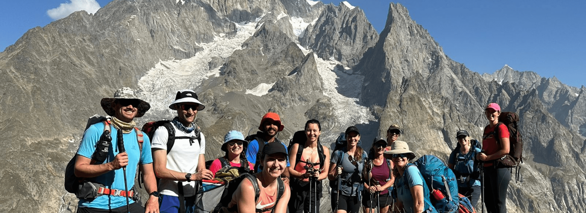Hikers on the Tour du Mont Blanc with Mont Blanc’s Italian-side glaciers and granite peaks rising above Val Veny.
