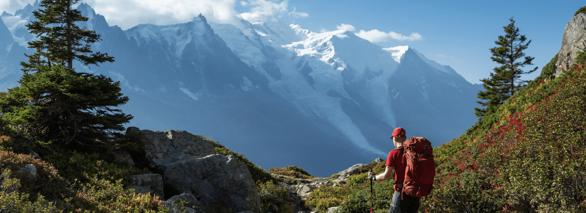 Hiker trekking above Chamonix with glaciers and Mont Blanc in view