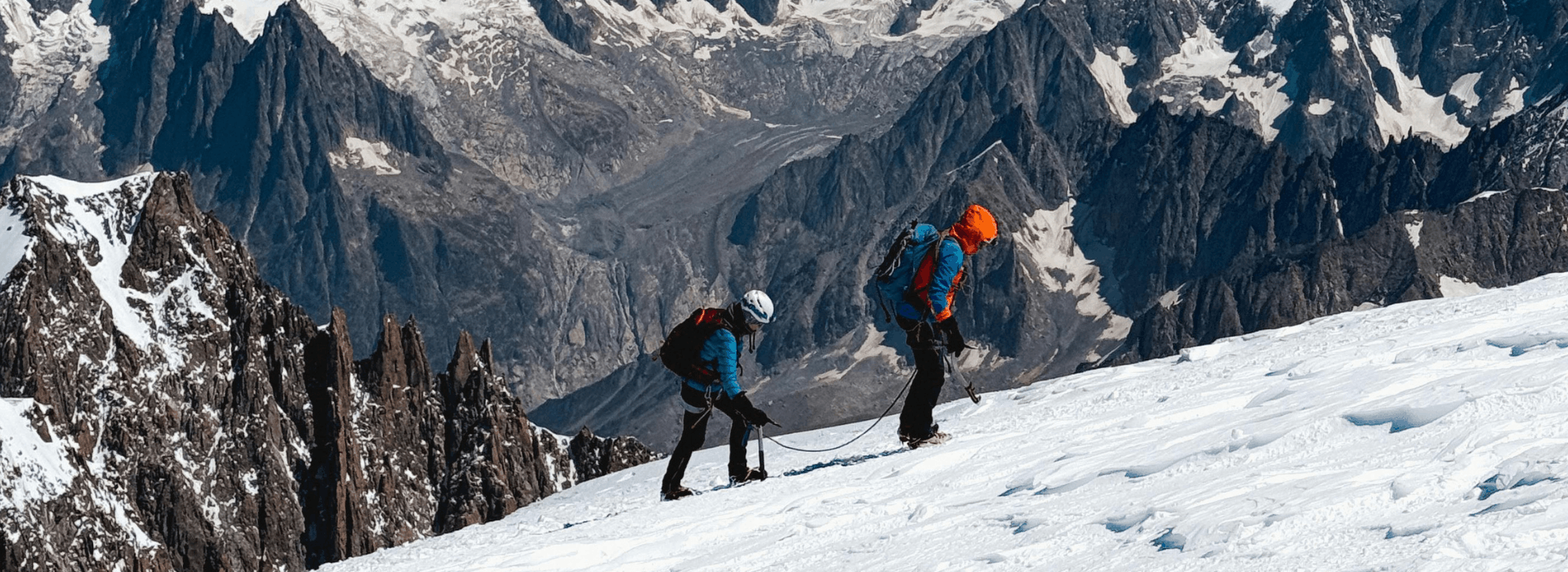 Image 2: Two mountaineers roped together on a steep snowy slope during winter skills training