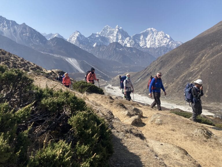 Trekkers on a clear day in the Khumbu region, with mountains in the background