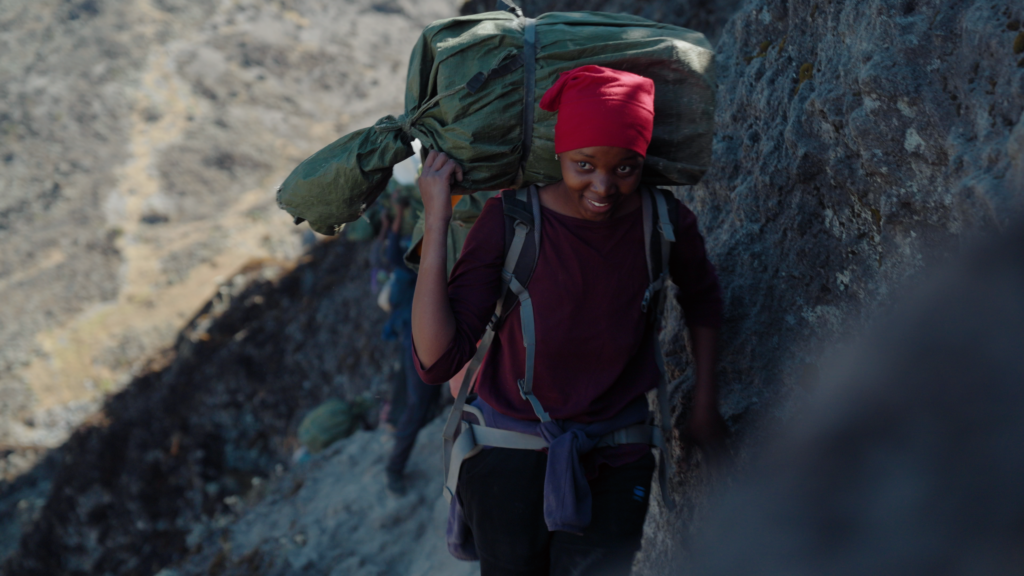 A female porter on Kilimanjaro carrying a bag on her back