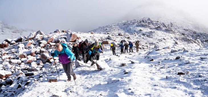 A group of trekkers climbing in the snow to the Lenana Peak, Mt. Kenya