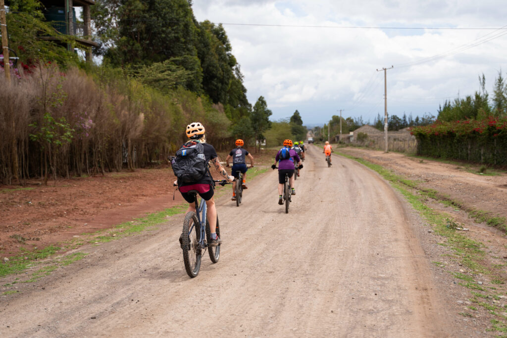 A group cycling through the overcast Kenyan countryside
