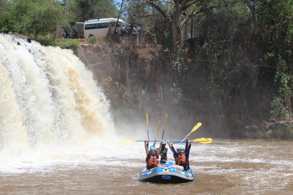 A group who are happy and posing for a photo while white-water rafting on the Tana River, Kenya