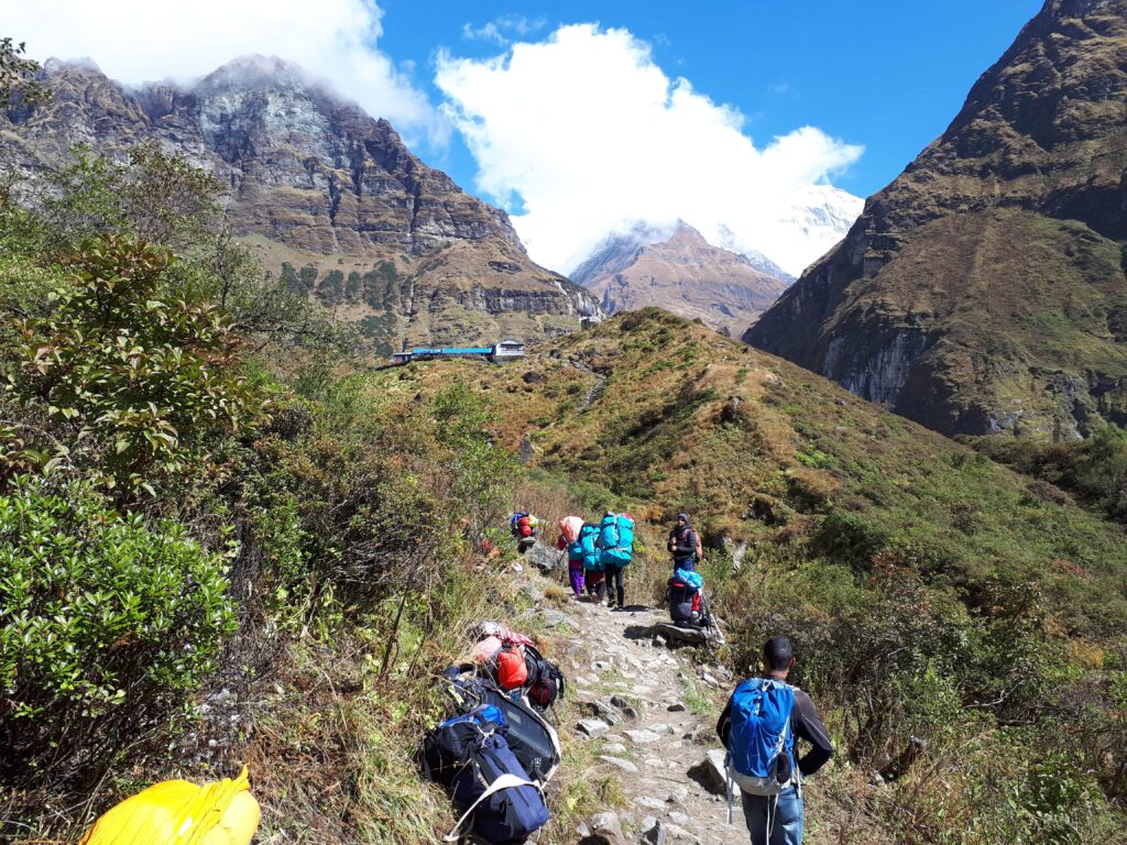 Trekkers hiking uphill in the Annapurna region towartd cloud-covered mountains, Nepal