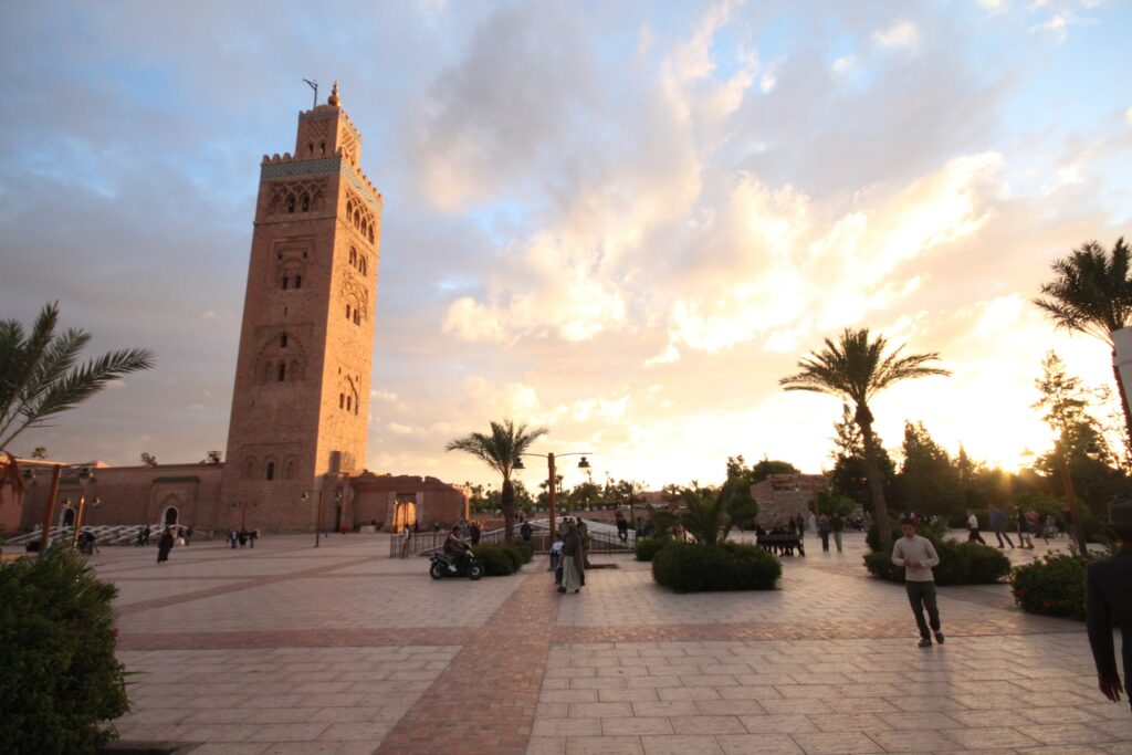 People wandering around a plaza at sunset in Marrakech, Morocco