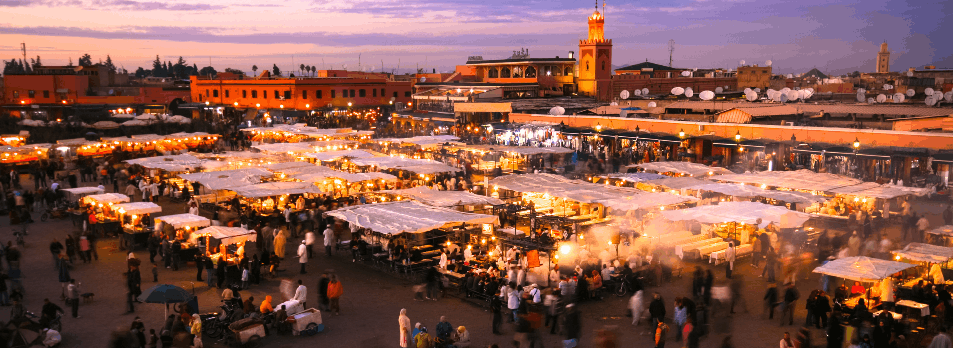 Evening scene at Jemaa el-Fnaa square in Marrakech with food stalls and crowds at dusk
